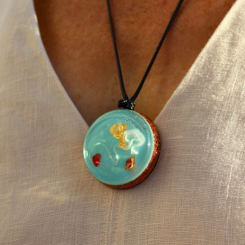 Pendentif orgonite Portail II Rayonnement en harmonie Horizon Azur porté avec corail coquillage et reflets dorés
