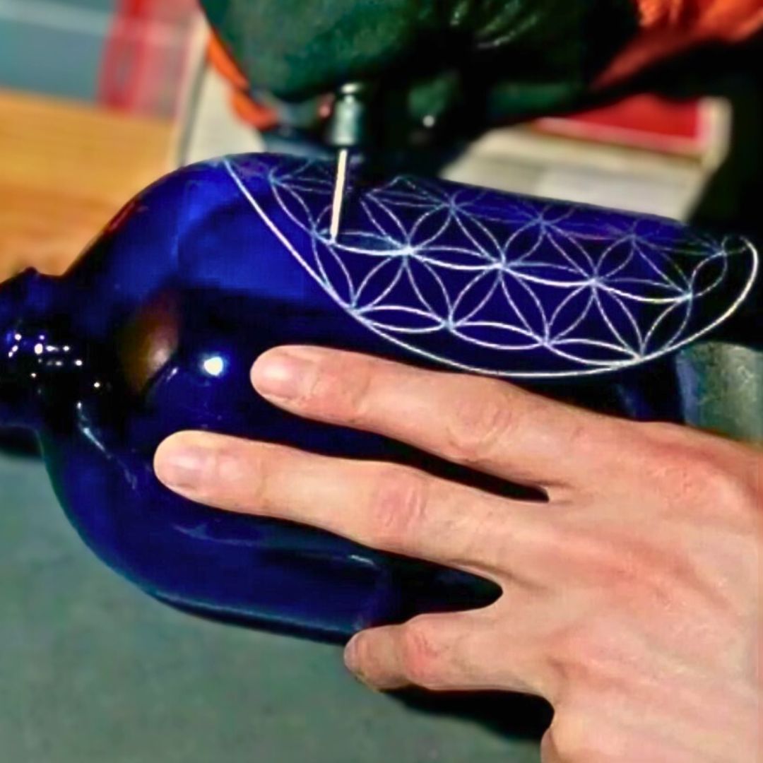 Gravure artisanale Fleur de Vie sur bouteille en verre bleu