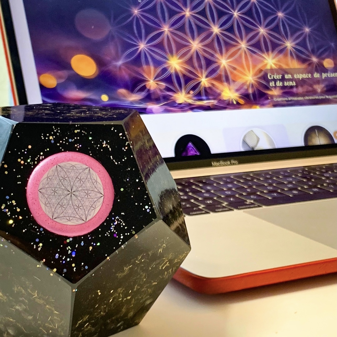 Orgonite placée sur un bureau à proximité d’un ordinateur, illustrant une approche symbolique d’harmonisation de l’environnement
